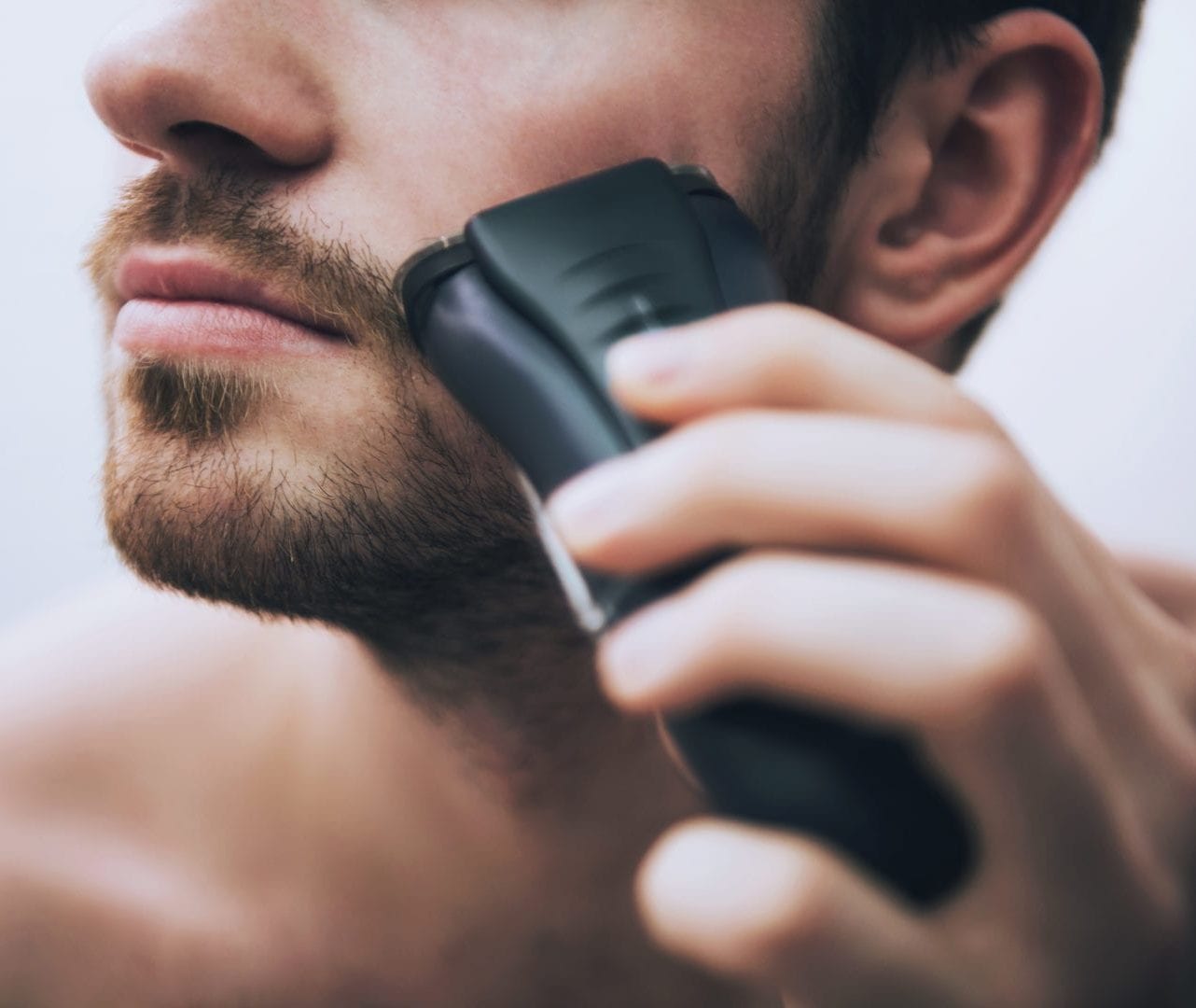 Man scheert zijn gezicht | droog scheren kan ingegroeide haren veroorzaken