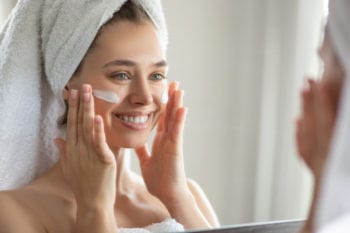 vrouw brengt creme aan op gezicht | huidverzorging